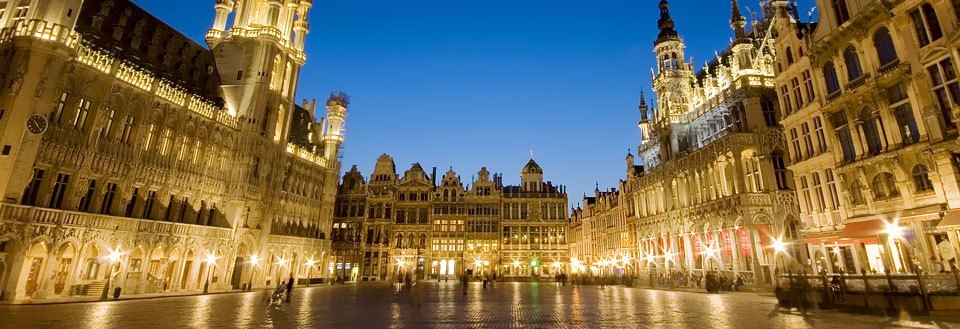 Billedet viser Grand Place i Bruxelles om aftenen, oplyst og imponerende med sin arkitektur.