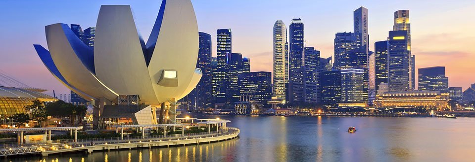 Et panorama af Singapore ved skumring med Marina Bay Sands og lotusformet museum.