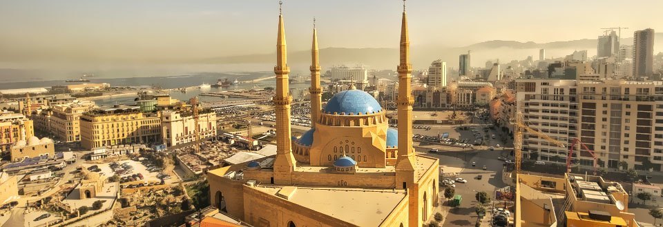 Beiruts solopgang med en prominent moské foran og moderne bygninger i baggrunden.