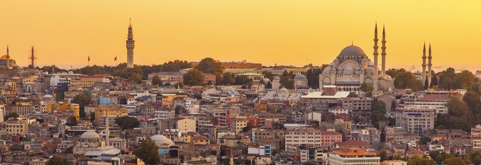 Istanbuls skyline ved solnedgang med historiske tårne og moskéer.